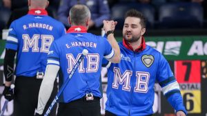 Manitoba-Dunstone skip Matt Dunstone, right, and second E.J. Harnden celebrate after defeating Brad Gushue's Canada rink during the Brier, in Kelowna, B.C., on Thursday, March 6, 2025. (Darryl Dyck/CP)