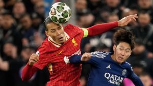 Liverpool's Virgil van Dijk, left, and PSG's Lee Kang-in battle for the ball during the Champions League round of 16 second leg soccer match between Liverpool and Paris Saint-Germain at Anfield in Liverpool, England, Tuesday, March 11, 2025. (Dave Thompson/AP Photo)