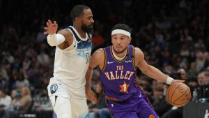 Phoenix Suns guard Devin Booker (1) drives on Minnesota Timberwolves guard Mike Conley (10) during the second half of an NBA basketball game, Sunday, March 2, 2025, in Phoenix. (Rick Scuteri/AP Photo)